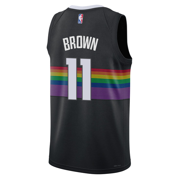 Back view of a black jersey. The player name 'BROWN' is printed across the upper back in bold white block letters, directly above the large white number '11'. A vibrant, horizontal multi-colored rainbow stripe pattern wraps around the midsection of the jersey behind the number. The official NBA logo is positioned near the top neckline, and white trim outlines the inside back collar.