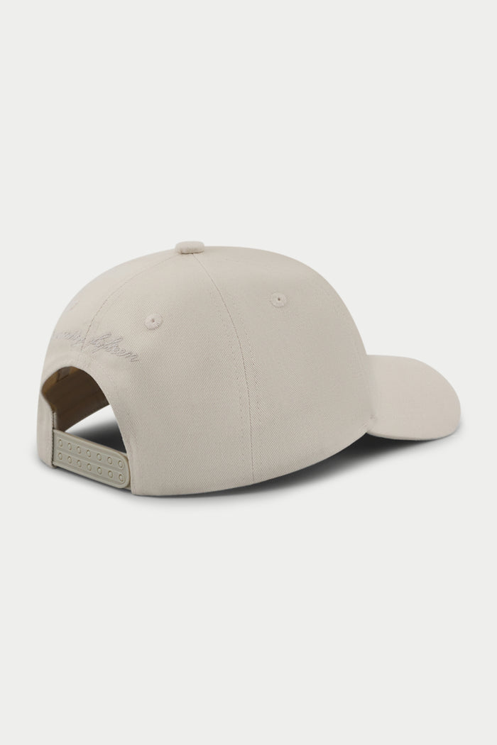 Beige cap with a white embroidered emblem logo on a white background