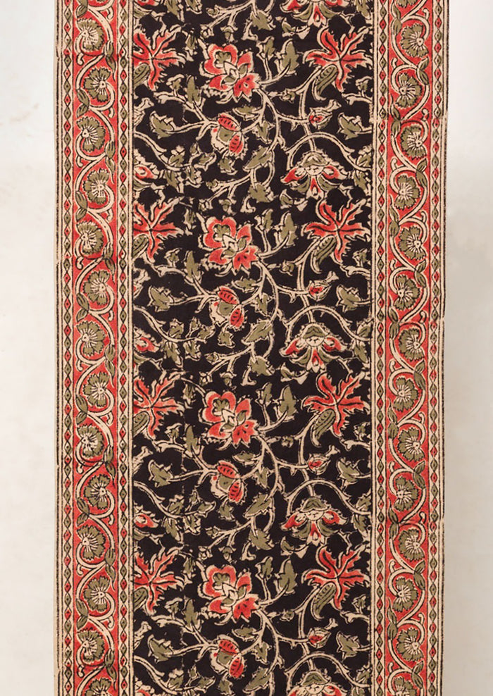 A table runner with black and red floral print.