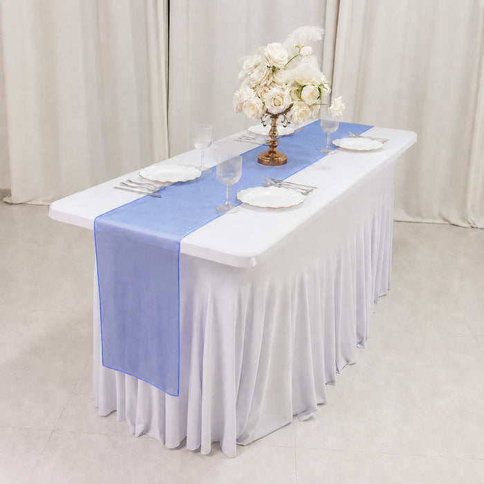 Elegant white banquet table with blue runner and floral centerpiece