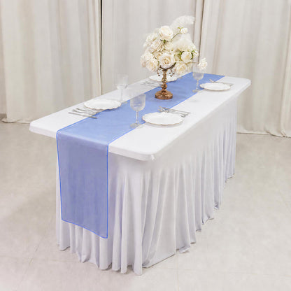 Elegant white banquet table with blue runner and floral centerpiece