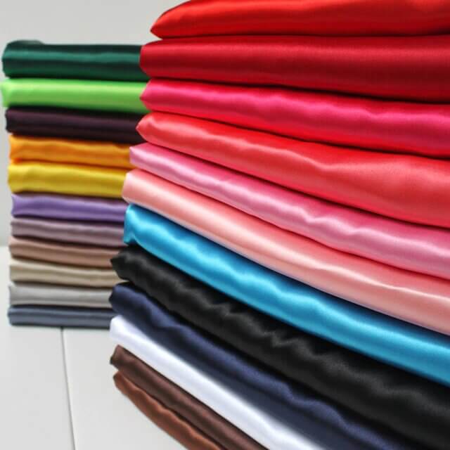 Colorful fabric swatches stacked neatly in various shades.