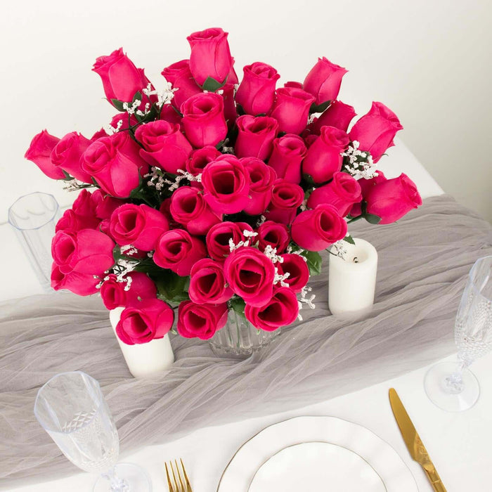 Bouquet of vibrant pink roses with delicate white accents on a dining table.