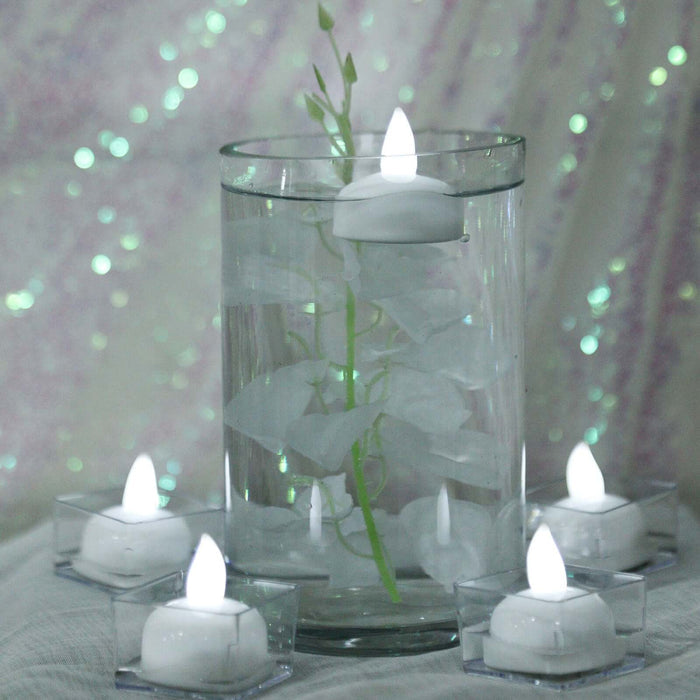 Floating candles in a glass vase with decorative elements.