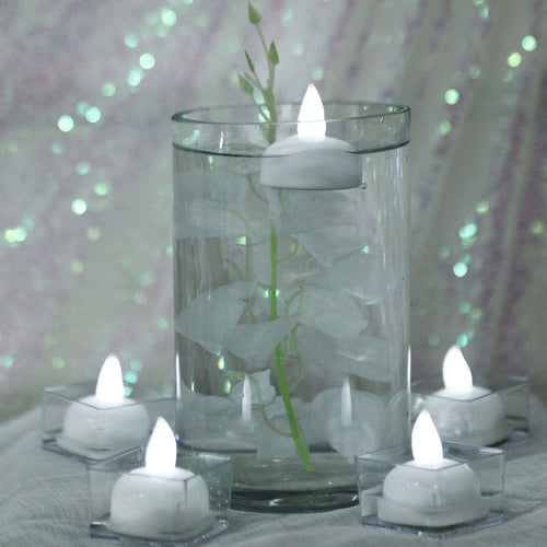 Floating candles in a glass vase with decorative elements.
