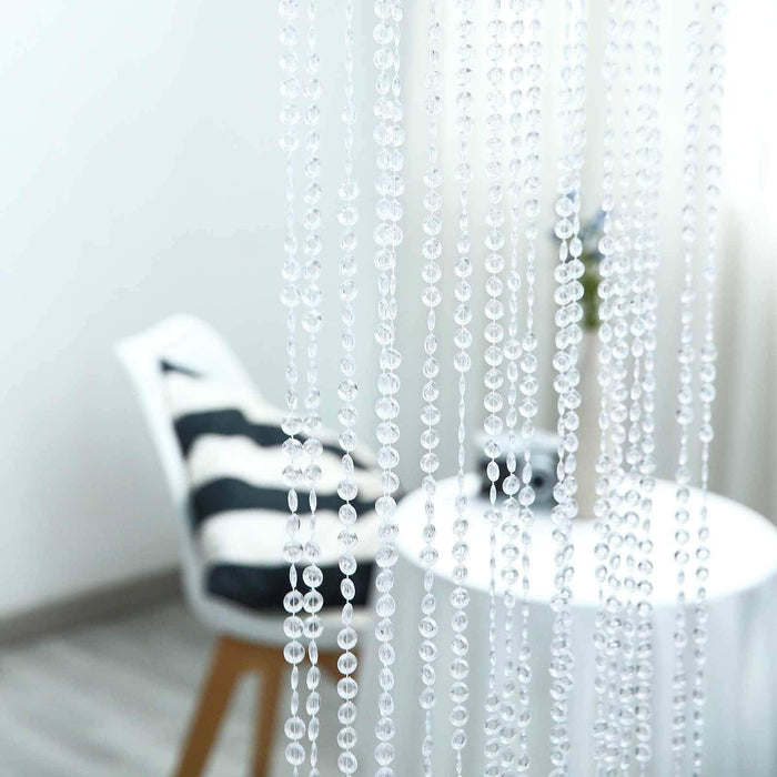 Transparent beaded curtain with blurred chair and table background.