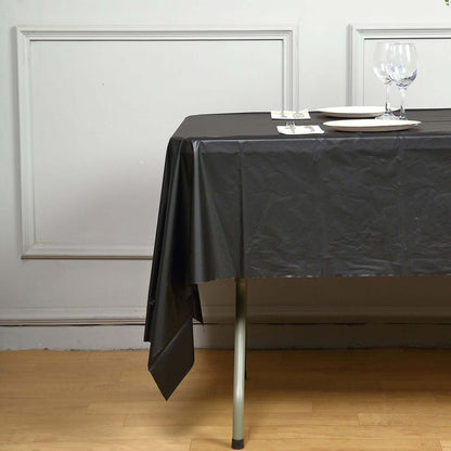 Black tablecloth draped over a table with plates and glasses