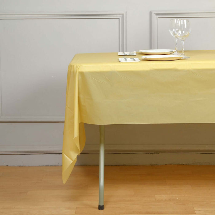 Yellow tablecloth draped over a table set with plates and glasses.