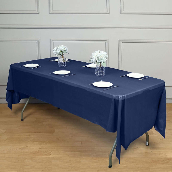 Navy blue tablecloth on a dining table set with plates and flowers.
