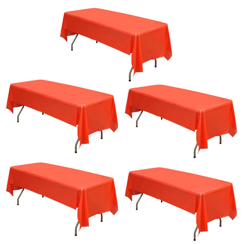 Five red tablecloths on folding tables arranged in a studio setting.