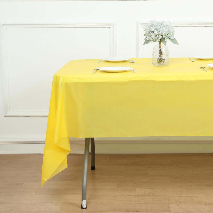 Yellow tablecloth draped elegantly over a table with floral centerpiece.