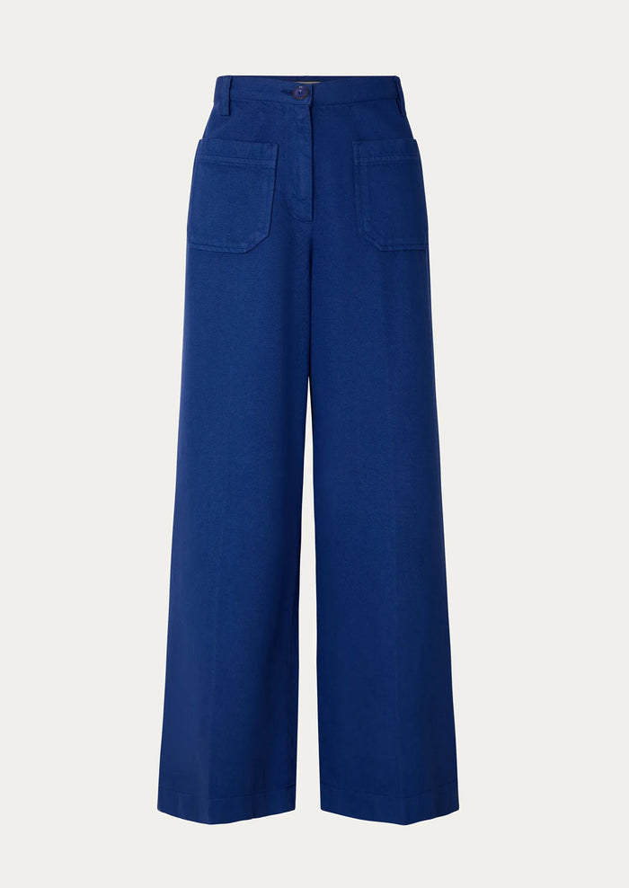 A person wearing a pair of blue wide leg pants with front patch pockets.