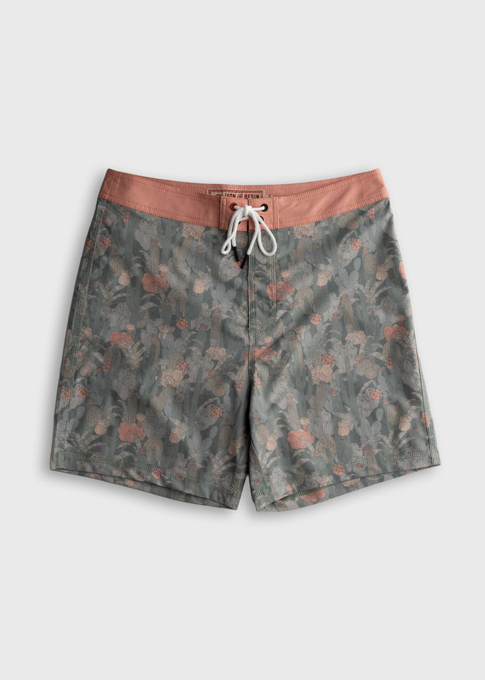 Floral-patterned swim trunks with a pink waistband and white drawstring, featuring a subtle cactus design on a gray background.