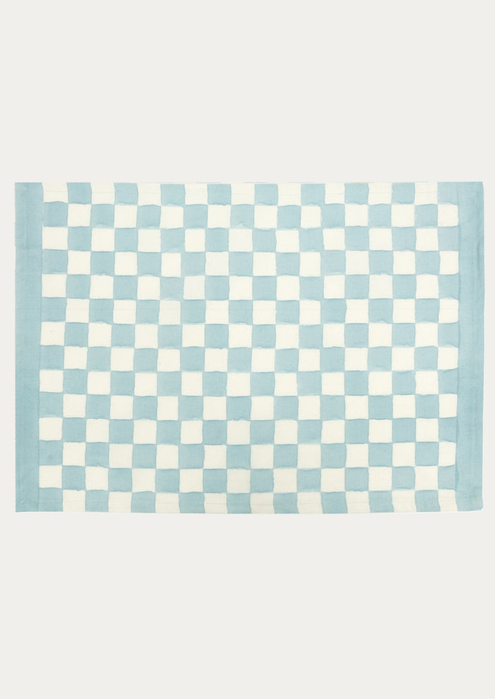 A block printed placemat with checkered pattern in sky blue.