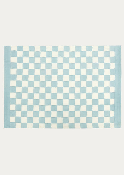 A block printed placemat with checkered pattern in sky blue.