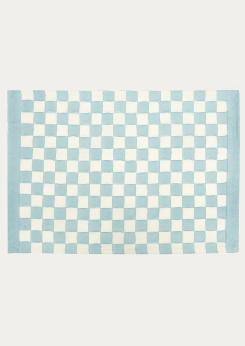 A block printed placemat with checkered pattern in sky blue.