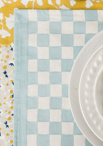 A block printed placemat with checkered pattern in sky blue.