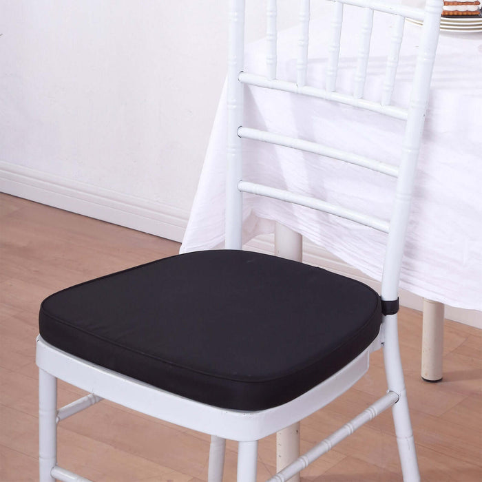 Black cushion on a white chiavari chair in a dining setting.