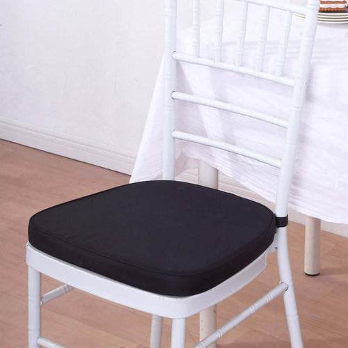 Black cushion on a white chiavari chair in a dining setting.