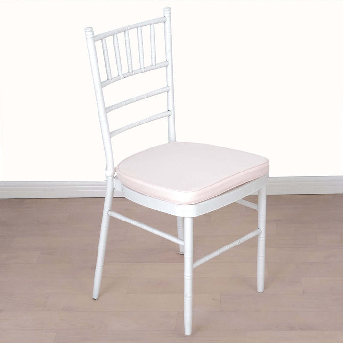 White chiavari chair with soft pink cushion on a plain backdrop