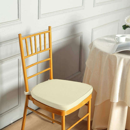 Elegant wooden chair with cream cushion beside a table.