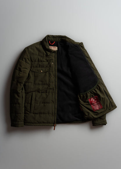 Olive green quilted jacket with open front, revealing black lining and red label inside. Features chest pocket and snap buttons.
