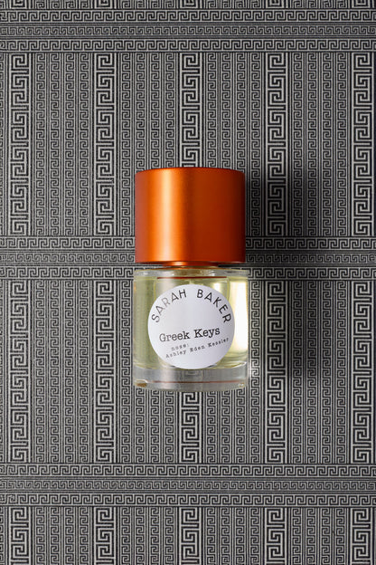 Sarah Baker Perfumes Greek Keys 50ml Extrait de Parfum bottle with red cap on Greek key meander pattern background