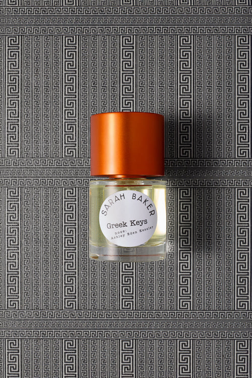 Sarah Baker Perfumes Greek Keys 50ml Extrait de Parfum bottle with red cap on Greek key meander pattern background
