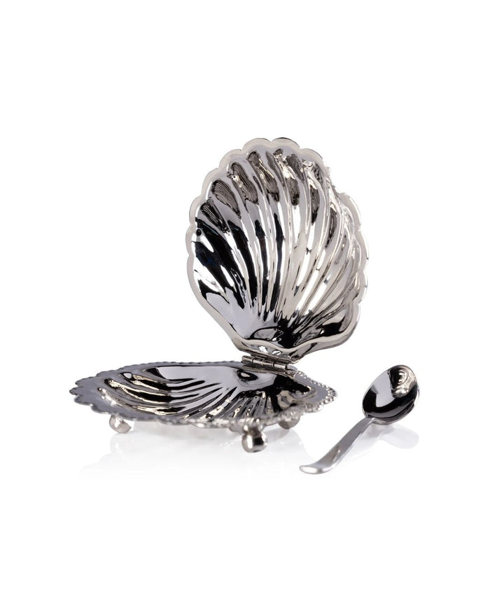 Silver shell-shaped bowl with a spoon on a white background