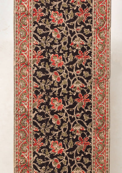 A table runner with black and red floral print.