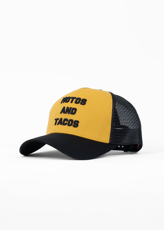 Yellow and black trucker hat with "NOTOS AND TACOS" text. The mesh back adds a casual, stylish touch to the design.