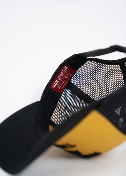 Black and yellow cap with mesh back, featuring an "Iron and Resin" label inside. The cap is partially open, showing its interior.