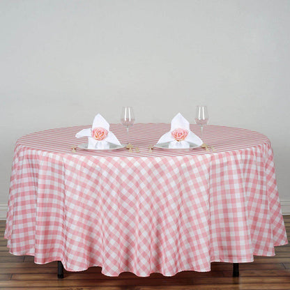Pink gingham tablecloth on a round table set with glasses and napkins.