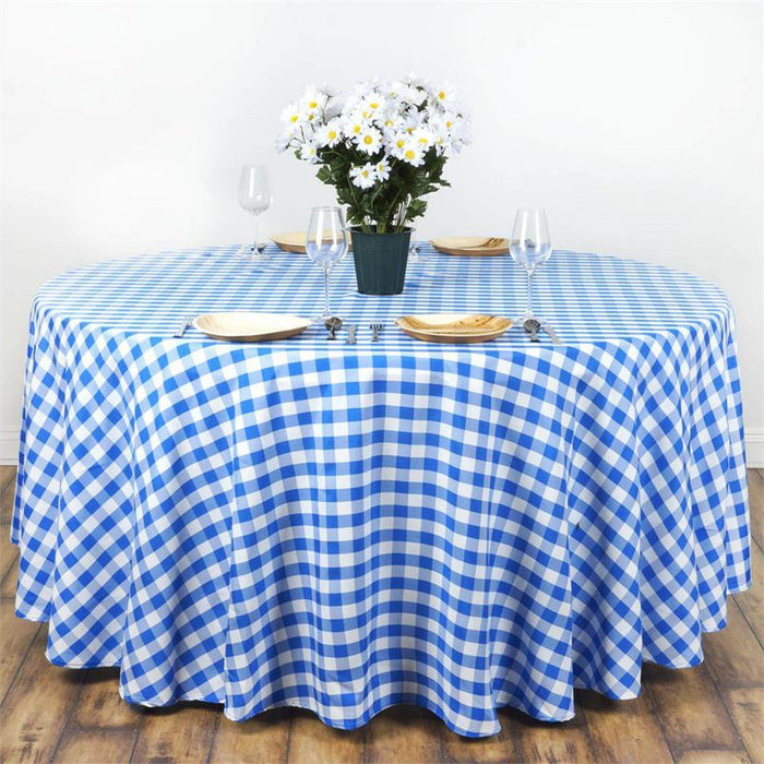 Blue and white checkered tablecloth on a round table with flowers and tableware.