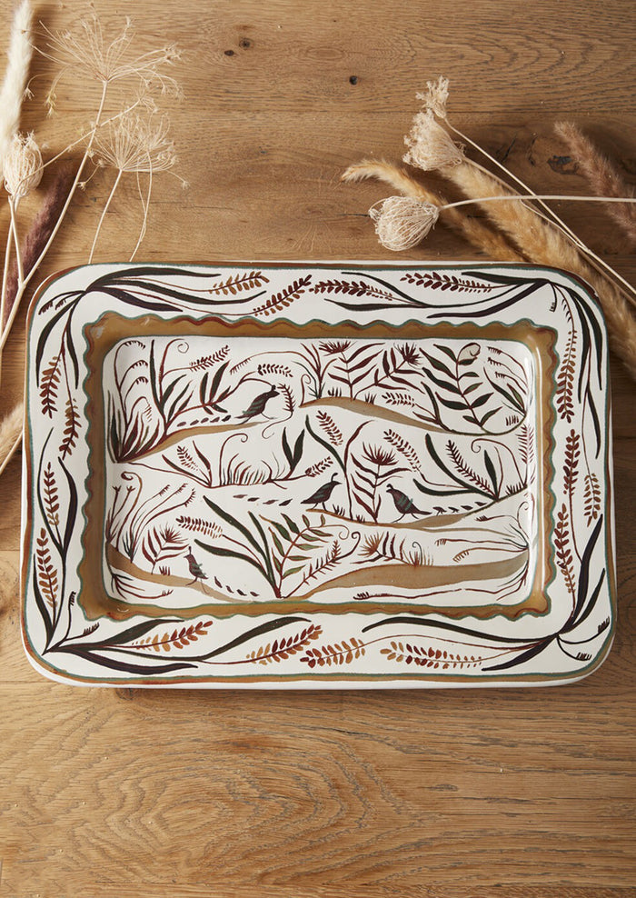 A rectangular ceramic platter with quail and nature pattern in brown.