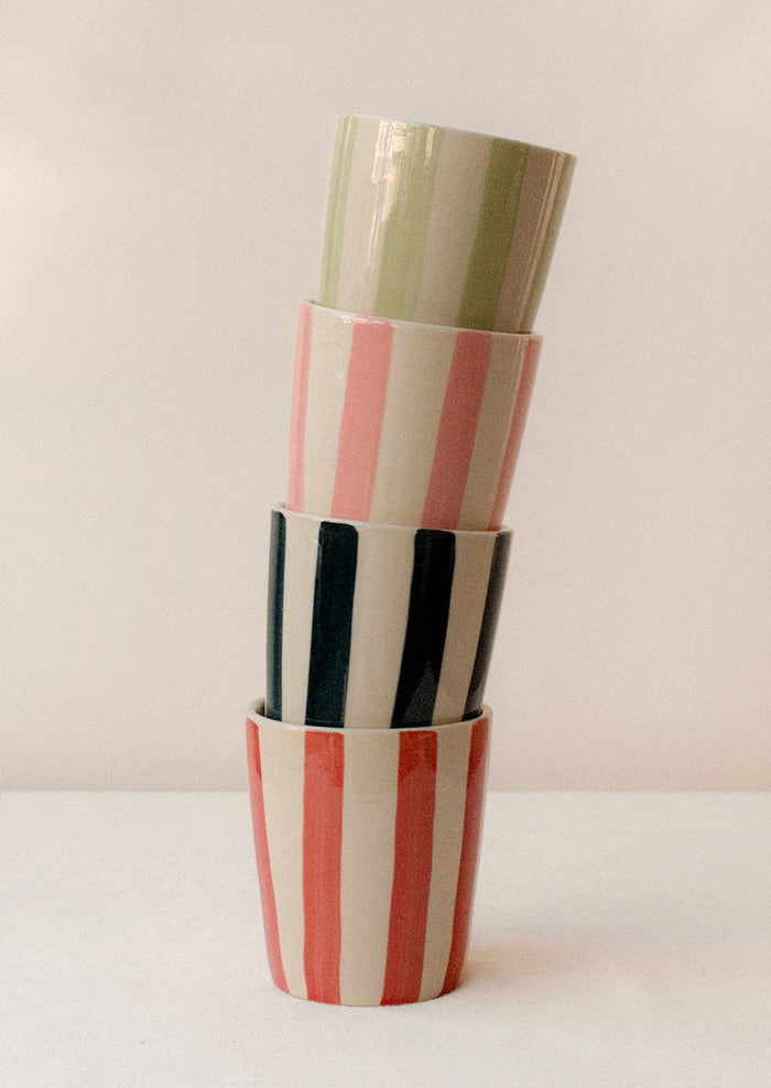 A stack of striped ceramic tumblers in assorted colors.