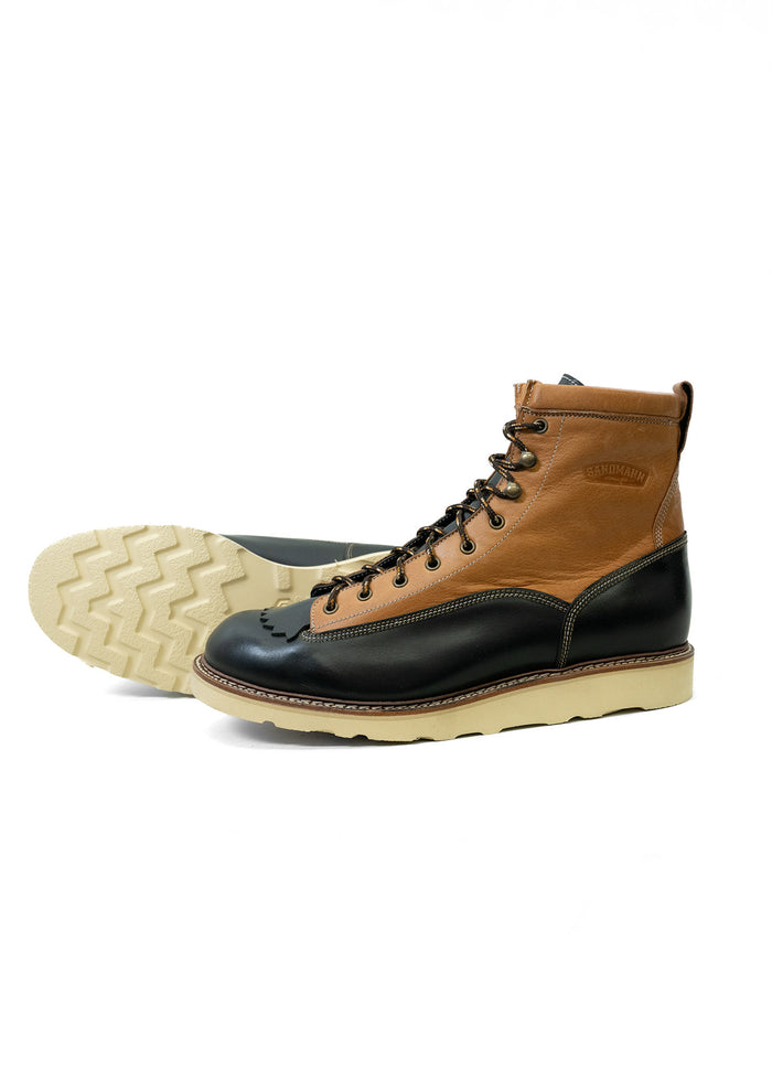 Brown and black leather boots with white soles, featuring detailed stitching and rugged design, displayed on a white background.