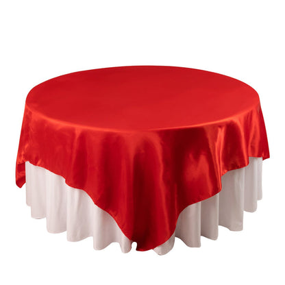 Red satin tablecloth draped elegantly over a round table