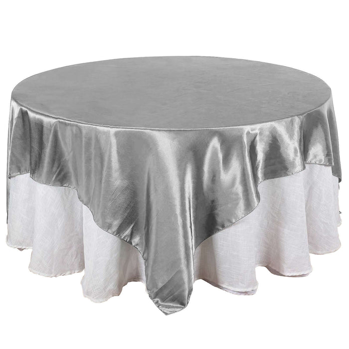 Round silver tablecloth with elegant drape, perfect for events and dining.