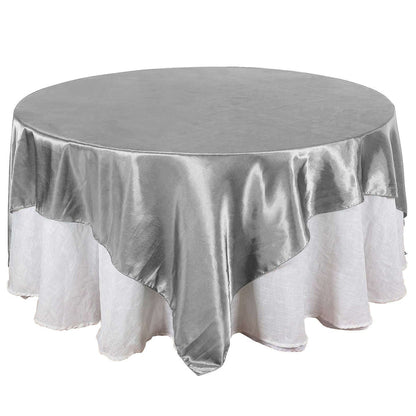 Round silver tablecloth with elegant drape, perfect for events and dining.
