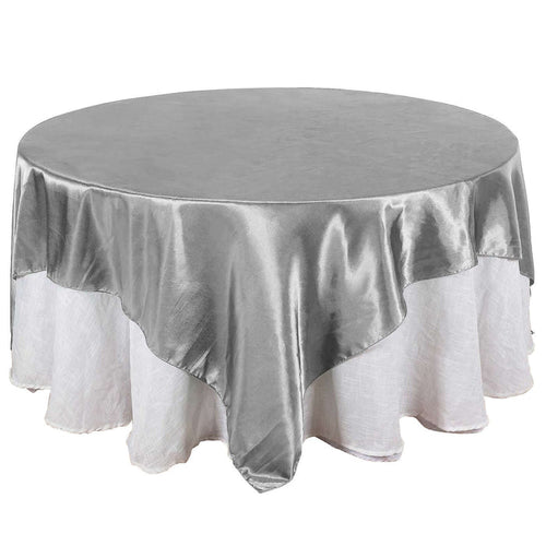 Round silver tablecloth with elegant drape, perfect for events and dining.