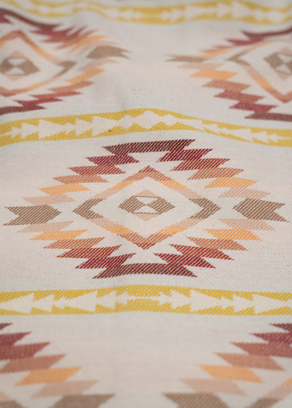 Geometric pattern with diamond shapes in earthy tones on fabric, featuring yellow, orange, and red hues.
