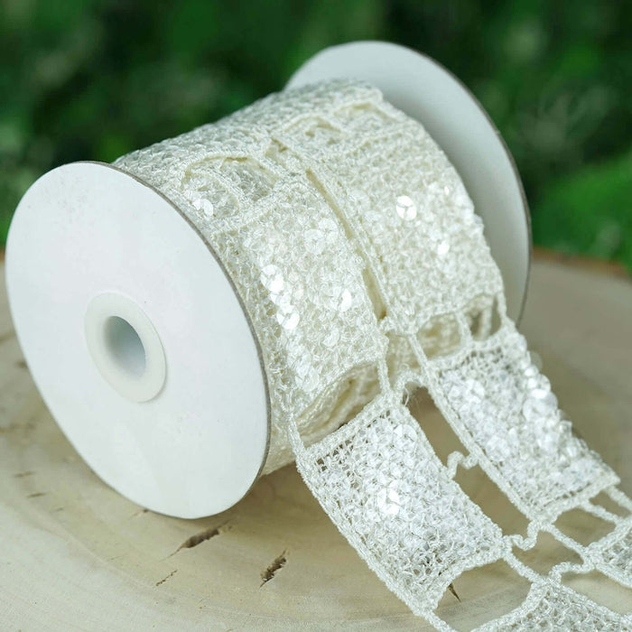 White decorative ribbon on a spool, featuring sequins and intricate lace design.