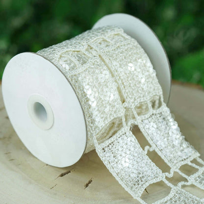 White decorative ribbon on a spool, featuring sequins and intricate lace design.