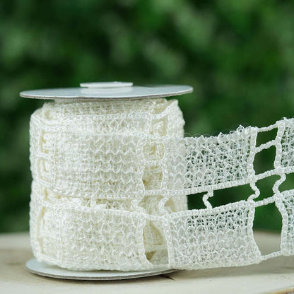 White lace ribbon on a spool, featuring a delicate open weave design.