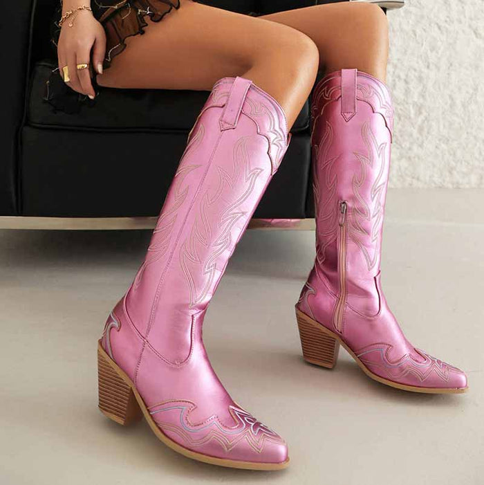 Stylish women's knee high cowboy boots in pink with decorative stitching and a sturdy heel